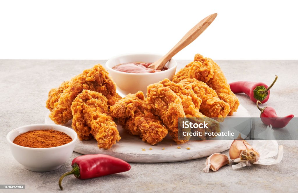Spicy chicken wings breaded with spices and ketchup on the table