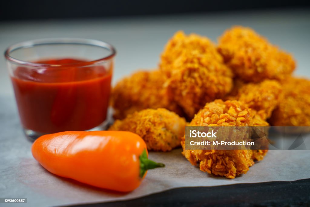 Fried crispy chicken nuggets with ketchup.
